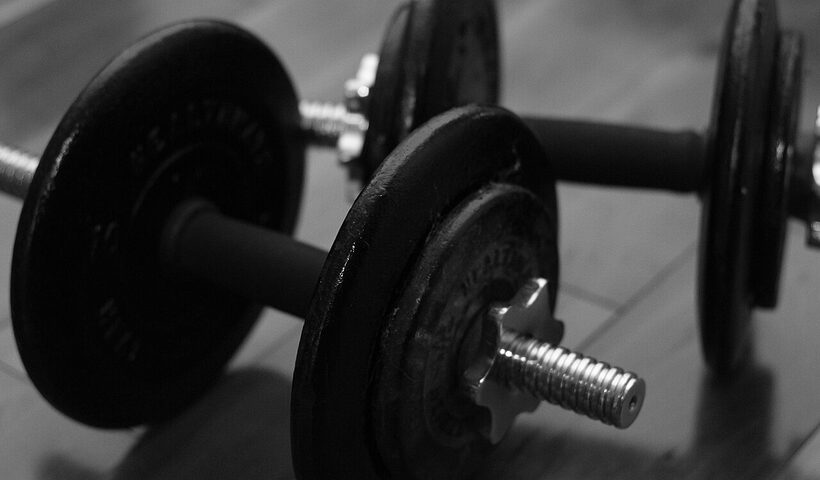 Black dumbbells arranged on the floor for a strength-training workout
